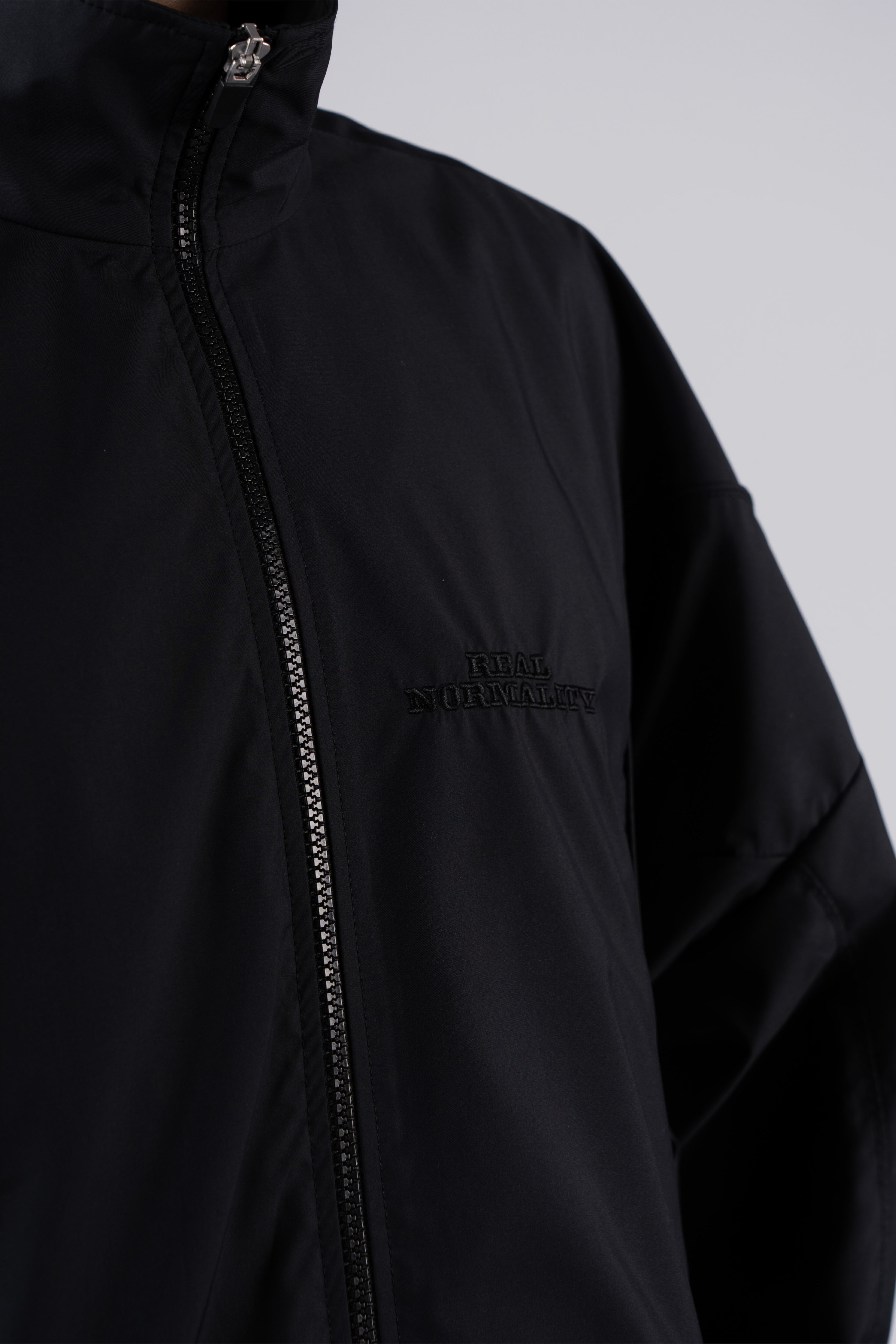 “REAL NORMALITY” Panelled Track Jacket - Black/Black